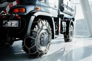 Jeep with snow chains parked indoors at the white tile on vehicle show photo