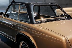 Automobile exhibition. Photo of brown vintage polished and shiny car parked indoors