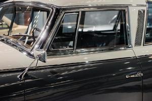 Left part of polihed shiny car standing indoor at automobile exhibition photo