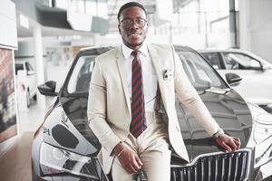 The young attractive black businessman buys a new car, dreams come true photo