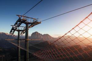 Sunlight going through the net. Cableway standing on the hills in Seceda dolomites photo