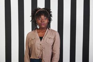 Some bad news. Beautiful female portrait on the black and blue stripes type background. African american girl makes shocked face photo