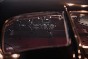 Inside of the iconic automobile through the back glass. Steering wheel, seats and speedometer photo