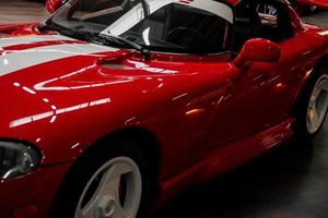 SINSHEIM, GERMANY - OCTOBER 16, 2018 Technik Museum. Left side of red sport car standing indoors at vehicle exhibition photo