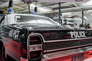 SINSHEIM, GERMANY - OCTOBER 16, 2018 Technik Museum. Particle view. Backing part of the police car that standing on white tile at vehicle exhibition photo