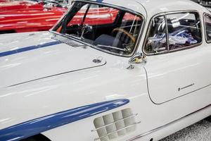 Sinsheim, Alemania - 16 de octubre de 2018 Technik Museum. vehículo rojo en el fondo. coche de época blanco con partes azules. exposición de automóviles foto
