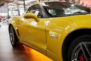 Sinsheim, Alemania - 16 de octubre de 2018 Technik Museum. Lado derecho del moderno coche amarillo con luz de neón y rueda delantera de color plateado. foto