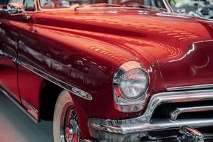 SINSHEIM, GERMANY - OCTOBER 16, 2018 Technik Museum. Red cherry color retro car on the vehicle exhibition. Nice light on the polished surface photo