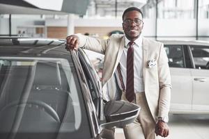 The young attractive black businessman buys a new car, dreams come true photo