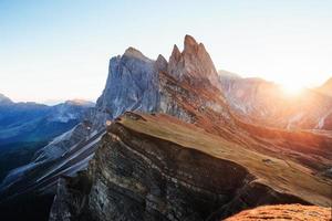 Variety of blue and yellow colors. Beautiful sunset in the Italian majestic Seceda dolomite mountains photo