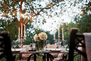 Outdoor restaurant. Prepared desk waiting for food and visitors. Evening time photo