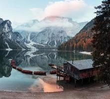 Boats keeps on the water. Good landscape with mountains. Touristic place with wooden building and pear photo