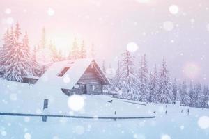 Living house in the mountains. Sunlight goes through the winter clouds. Carpathian forests in Ukraine photo