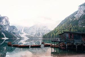 Many of boats in on the water. Good landscape with mountains. Touristic place with wooden building and pear photo