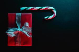 Minimal Christmas composition. Greeting card template with candy cane on dark background. photo