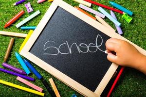 top view, school accessories on green grass. Back to school concept photo