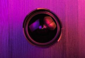 Fish eye lens. Pink light. Workspace top view. Wood background photo