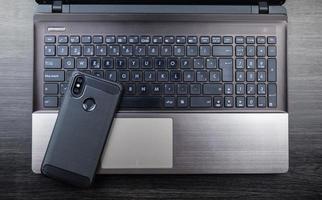 Modern notebook and smartphone copy space. Mobile with dual camera and fingerprint reader photo