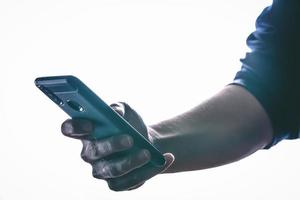 hands holding and texting in a smartphone with back light and copy space photo