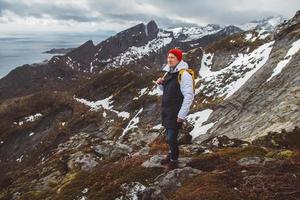 Hombre viajero senderismo en la cresta de la montaña reinebringen en Noruega viajes de aventura en el estilo de vida foto