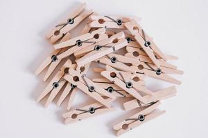 Wooden clothespins scattered on a white background. View from above. Copy space photo