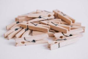 Wooden clothespins scattered on a white background photo