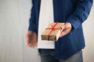 Persona con caja de regalo, caja de regalo de año nuevo, caja de regalo de Navidad, espacio de copia. Navidad, año nuevo, concepto de cumpleaños. foto