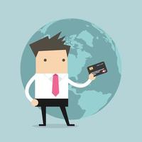 Businessman standing holding his a credit card in front of the globe. vector