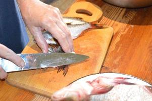 Cut fresh river fish with a knife photo