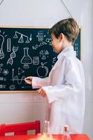 Kid showing drawings on chalkboard with marker photo