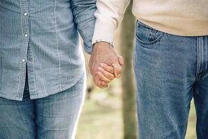 Senior couple holding hands over nature background photo