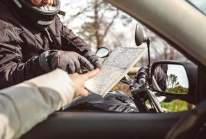 motociclista preguntando por la dirección del mapa foto