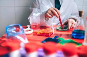 Boy hands playing to be chemist with colorful liquids photo