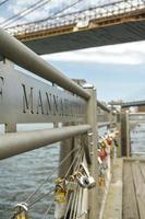 Ciudad de Nueva York, EE.UU. - 21 de junio de 2016.El amor bloquea en la valla con East River en el fondo foto