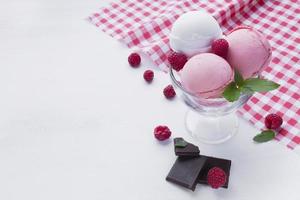 vaso helado de vainilla y frambuesas. concepto de foto hermosa de alta calidad