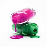 close up pink green nail polish dripping from bottle photo