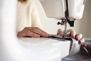 close up person using sewing
