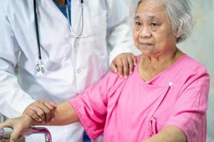 Asian nurse physiotherapist doctor touching Asian senior or elderly old lady woman patient with love, care, helping, encourage and empathy at nursing hospital ward, healthy strong medical concept.