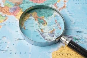 Bangkok, Thailand - August 01, 2020 Asia, Magnifying glass close up with colorful world map photo