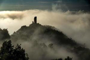 castle shrouded in morning fog on an autumn day in Italy photo