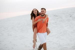 young couple in orange clothes with dog photo