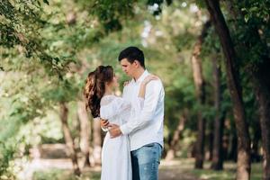 guy and a girl walk along the paths of a forest park photo