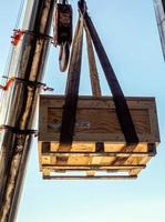 la grúa levantando el portainstrumentos radiactivos transporte caja de madera foto