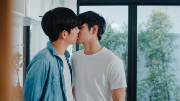 Asian Gay couple standing and hugging room at home. Young handsome LGBTQ men kissing happy relax rest together spend romantic time in modern kitchen at house in the morning concept. photo