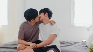Asian Gay couple kissing on bed at home. Young Asian LGBTQ men happy relax rest together spend romantic time after wake up in bedroom at home in the morning concept. photo