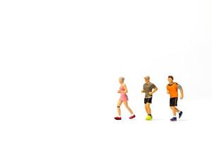 Miniature people running on white background photo