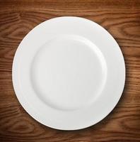 Empty white plate on wooden table photo