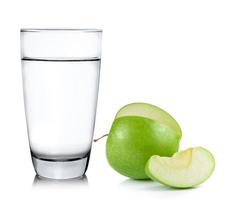 Vaso de agua y manzana aislado sobre fondo blanco.
