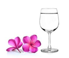 Vaso de agua y flor de frangipani aislado fondo blanco. foto
