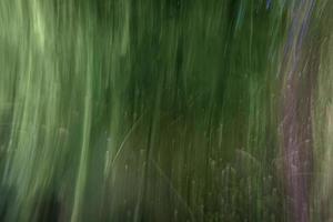 Fondo verde sucio abstracto con reflejos verticales, manchas y arañazos. foto